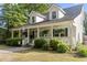 Charming home with a covered front porch, complete with inviting decor and manicured landscaping at 228 Hopeland St., Pawleys Island, SC 29585