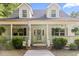 Inviting front porch with ferns, brick steps, and a decorative door at 228 Hopeland St., Pawleys Island, SC 29585