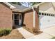 Close up of a brick entryway with a screen door and attached two-car garage at 2405 Brick Dr., Longs, SC 29568