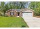 Charming brick home with a well-manicured lawn and a two-car garage at 2405 Brick Dr., Longs, SC 29568