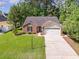 Aerial view of a brick home with an attached two-car garage, a well manicured lawn, and mature trees at 2405 Brick Dr., Longs, SC 29568