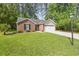 Lovely brick home with a green lawn, bench, and attached two-car garage at 2405 Brick Dr., Longs, SC 29568