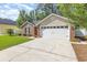 A view of the two-car garage with a brick exterior and a well-kept lawn at 2405 Brick Dr., Longs, SC 29568