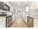 Bright kitchen featuring tile floors, stainless steel appliances, and white cabinets with eat-in dining area at 2405 Brick Dr., Longs, SC 29568