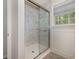 Bathroom shower with glass doors, white panels, and a window at 2405 Brick Dr., Longs, SC 29568