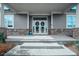 Elegant entryway with double doors adorned with wreaths and stone accents at 290 Woodlands Way Nw # 10, Calabash, SC 28467