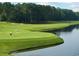 Scenic golf course view with lush green fairways and water feature, perfect for golf enthusiasts and nature lovers at 290 Woodlands Way Nw # 10, Calabash, SC 28467