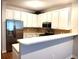 Beautiful kitchen with white cabinets, stainless steel appliances, and an open view of the living area at 290 Woodlands Way Nw # 10, Calabash, SC 28467