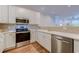 Bright kitchen featuring white cabinets, stainless steel appliances, and laminate flooring at 290 Woodlands Way Nw # 10, Calabash, SC 28467