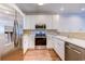 Modern kitchen with stainless steel appliances, white cabinets, and mosaic backsplash at 290 Woodlands Way Nw # 10, Calabash, SC 28467