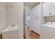Bright laundry room with utility sink, storage cabinets, and doorway to another room at 290 Woodlands Way Nw # 10, Calabash, SC 28467