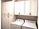 Bright laundry room features a washer and dryer along with ample cabinet storage at 290 Woodlands Way Nw # 10, Calabash, SC 28467