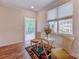 Bright living room featuring wood floors, large window with seating and access to screened porch at 290 Woodlands Way Nw # 10, Calabash, SC 28467