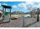 Fun playground area with a slide, swings, and view of the nearby pond and apartments at 290 Woodlands Way Nw # 10, Calabash, SC 28467