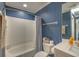 Traditional bathroom features a shower-tub combo with blue striped wallpaper and white fixtures and finishes at 307 Golden Bear Dr. # 3, Pawleys Island, SC 29585