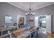 Elegant dining room with rustic wood table, chandelier, and access to kitchen at 307 Golden Bear Dr. # 3, Pawleys Island, SC 29585