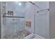 This walk-in shower features marble walls, a pebbled floor, and a built-in seat, perfect for relaxing at 307 Golden Bear Dr. # 3, Pawleys Island, SC 29585