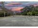 Well-maintained tennis court with lighting, surrounded by lush greenery and beautiful sunset skies at 307 Golden Bear Dr. # 3, Pawleys Island, SC 29585