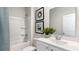 Clean, white bathroom with a shower-tub combo, patterned art, and single vanity at 311 Glade Ct., Loris, SC 29569