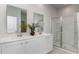 Well-lit bathroom with double vanity, white cabinets, and glass-enclosed shower at 311 Glade Ct., Loris, SC 29569