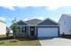Charming single-story home with gray siding, a two-car garage, and a well-maintained front yard at 311 Glade Ct., Loris, SC 29569