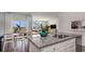 Well-lit kitchen island with granite countertops and stainless steel appliances, leading to an open dining and living area at 311 Glade Ct., Loris, SC 29569