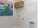 Bright laundry room with white walls, wire shelving, and vibrant, colorful artwork at 311 Glade Ct., Loris, SC 29569