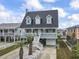 Charming raised beach house with metal roof, white railings, a garage, and tropical landscaping at 312 47Th Ave. N, North Myrtle Beach, SC 29582