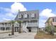 Charming two-story home with a metal roof, white railing, fountain, and palm trees in the front yard at 312 47Th Ave. N, North Myrtle Beach, SC 29582
