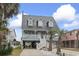 Charming two-story home with a metal roof, white railing, fountain, and palm trees in the front yard at 312 47Th Ave. N, North Myrtle Beach, SC 29582