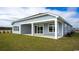 View of the backyard featuring a covered patio with white columns and large sliding glass doors, plus a well-maintained lawn at 334 Glacier Way, Conway, SC 29526
