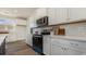 Stylish kitchen boasts white cabinetry, quartz countertops, modern backsplash, and stainless steel appliances at 334 Glacier Way, Conway, SC 29526