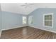 Spacious bedroom with a ceiling fan, wood-look floors, and multiple windows at 409 Hunley Ln., Myrtle Beach, SC 29577