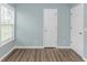 Bright bedroom features wood-look floors, a large window with blinds, and neutral paint at 409 Hunley Ln., Myrtle Beach, SC 29577