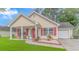 Charming single-story home featuring a well-manicured lawn, red shutters, and a cozy front porch sitting area at 409 Hunley Ln., Myrtle Beach, SC 29577