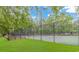 Outdoor tennis court surrounded by trees and manicured landscaping on a clear day at 409 Hunley Ln., Myrtle Beach, SC 29577