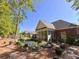 Landscaped backyard with a pond, screened-in porch, brick facade, and lots of greenery at 4266 Arabella Way, Little River, SC 29566