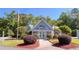 Bellacroft clubhouse with a manicured lawn, an American flag, and colorful shrubs at 4266 Arabella Way, Little River, SC 29566