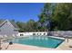 Sparkling community pool with lounge chairs, clear signage, and shade trees in the background at 4266 Arabella Way, Little River, SC 29566