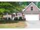 Charming brick home featuring a manicured lawn, mature trees, and an attached two-car garage at 4266 Arabella Way, Little River, SC 29566
