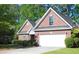 Brick home featuring an attached two-car garage, lush greenery, and a well-maintained lawn at 4266 Arabella Way, Little River, SC 29566