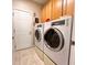 Functional laundry room featuring a front-load washer/dryer, tile floors, and cabinets at 4266 Arabella Way, Little River, SC 29566