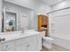 Bright bathroom with a white vanity, sink, toilet, bathtub, and a storage cabinet for towels and toiletries at 4698 Cloisters Ln., Myrtle Beach, SC 29577