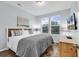Bright bedroom with a comfortable bed, two windows, stylish decor, and wood-look flooring at 4698 Cloisters Ln., Myrtle Beach, SC 29577