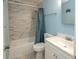 Bathroom featuring marble-look shower over tub, blue walls and white vanity at 5000 N Ocean Blvd. # F2, North Myrtle Beach, SC 29582