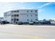 Exterior view of the condo building, showcasing parking facilities and proximity to the road and beach at 5000 N Ocean Blvd. # F2, North Myrtle Beach, SC 29582
