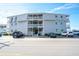 Attractive condo building with gray siding, white railings, and well-maintained landscaping, located near the beach at 5000 N Ocean Blvd. # F2, North Myrtle Beach, SC 29582