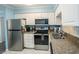 Well-equipped kitchen with stainless steel appliances, granite countertops, and white cabinets at 5000 N Ocean Blvd. # F2, North Myrtle Beach, SC 29582