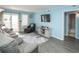 Comfortable living room with sliding glass doors to balcony, wood flooring, and a mounted TV at 5000 N Ocean Blvd. # F2, North Myrtle Beach, SC 29582