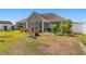 Exterior view of the backyard with screened in porch, chairs, and landscaped yard at 509 Fallen Leaf Ct., Myrtle Beach, SC 29588